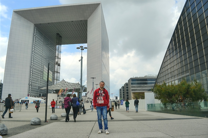 15 - Person posing near The Grande Arche de la Défense in Paris